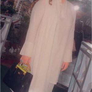 White silk satin kind of fabric. Very elegant would fit medium to large .